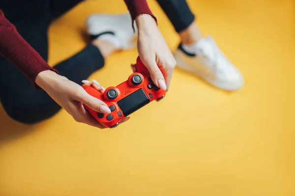Young woman playing with gamepad on yellow. — Stock Photo, Image