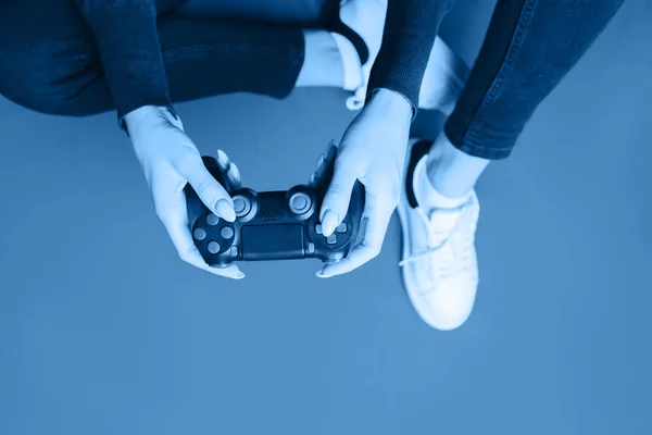 Ung kvinne som leker med gamepad på rødt . – stockfoto