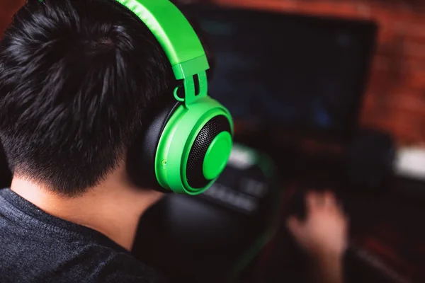 Visão traseira do jogador em fones de ouvido jogando videogame — Fotografia de Stock