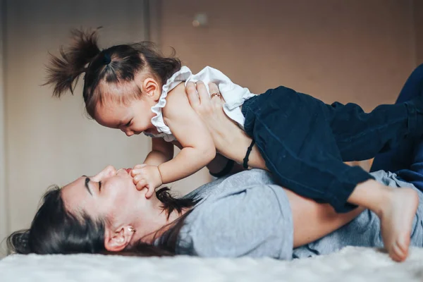 Mãe feliz brincando com seu bebê menina — Fotografia de Stock