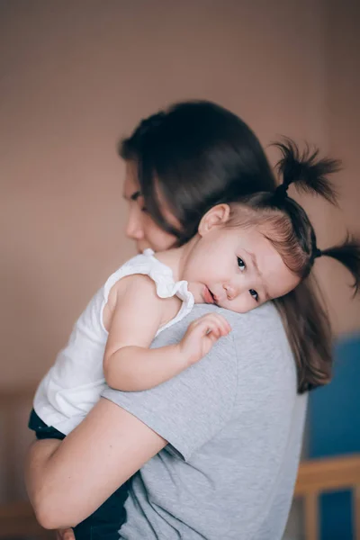 Jonge moeder houdt haar kleine kind meisje. — Stockfoto