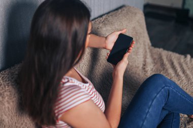 Siyah boş ekranlı akıllı telefonu tutan ve kullanan kadın.