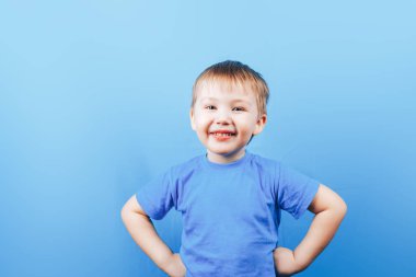 Mavi arka planda mutlu küçük bir çocuğun portresi