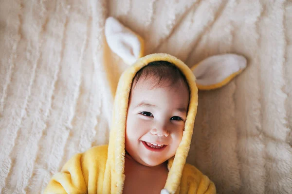 Un bambino piccolo con un costume da coniglio. Sdraiato sul male — Foto Stock