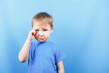Üzgün ağlayan üzgün çocuk mavi arka planda