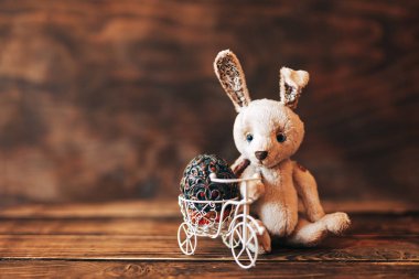 Paskalya bitisinde klasik yumurta, bisikletin yanında oturan tavşan.