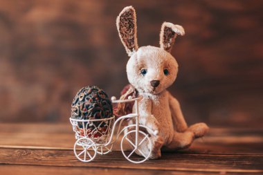 Paskalya bitisinde klasik yumurta, bisikletin yanında oturan tavşan.