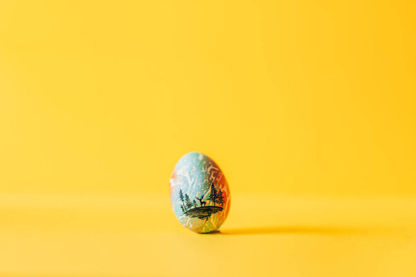 Пасхальное яйцо на желтом фоне
