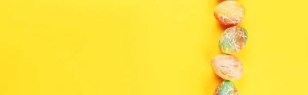 Bovenaanzicht van kleur paaseieren verschillen patronen. Regel eieren op gele achtergrond — Stockfoto