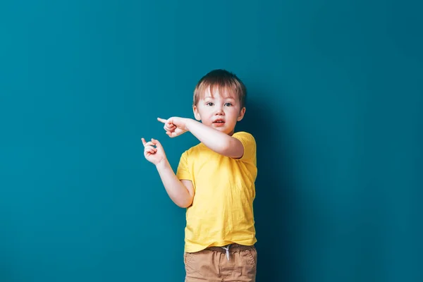 Menino no fundo azul, surpreso mostrar dedos — Fotografia de Stock