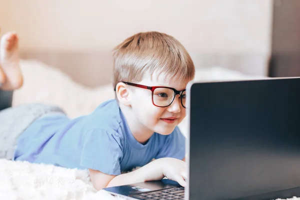 Pequeño niño rubio feliz usando el ordenador portátil — Foto de Stock