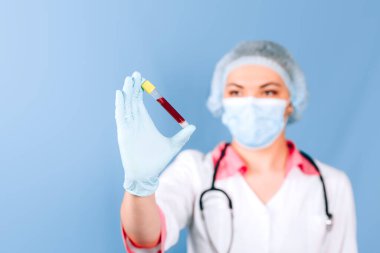 Doktor elinde test tüpü tutuyor.