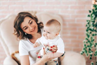 Anneler Günü. Genç ve güzel anne küçük bebeğine sarılıyor.