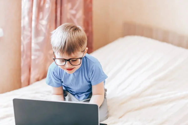 Pequeño niño rubio feliz usando el ordenador portátil —  Fotos de Stock