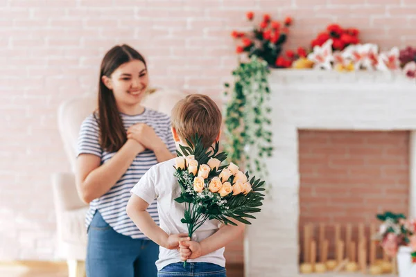 Junge hält einen Blumenstrauß hinter seinem Rücken — Stockfoto