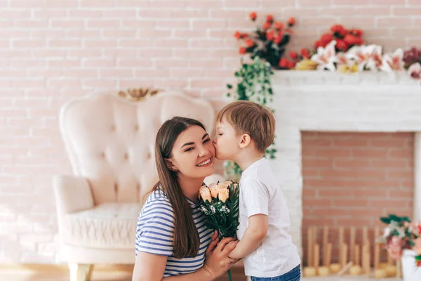 Der Junge schenkt Mama einen schönen Blumenstrauß — Stockfoto