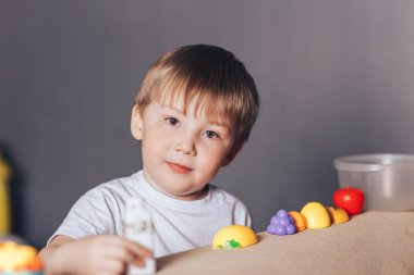 Bir çocuk evdeki bir mağazada oynuyor.