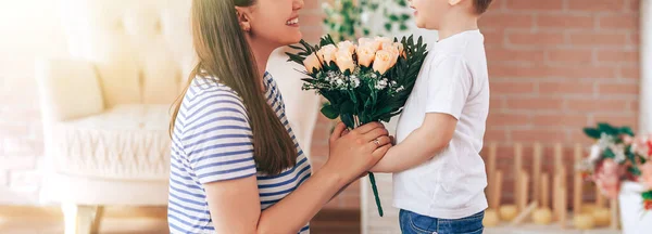 The boy gives beautiful bouquet of flowers to mom — Stock Photo, Image