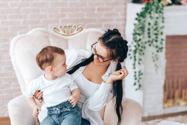 Annesiyle oturan küçük çocuk.