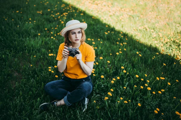 Turuncu Tişörtlü Genç Bir Kız Elinde Retro Kamerayla Çimlere Uzanmış — Stok fotoğraf