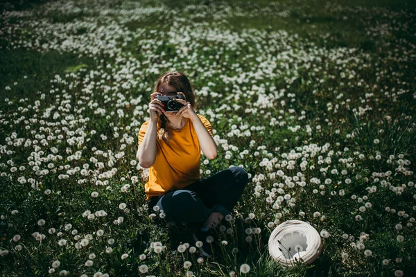 Turuncu Tişörtlü Genç Bir Kız Elinde Retro Kamerayla Çimlere Uzanmış — Stok fotoğraf