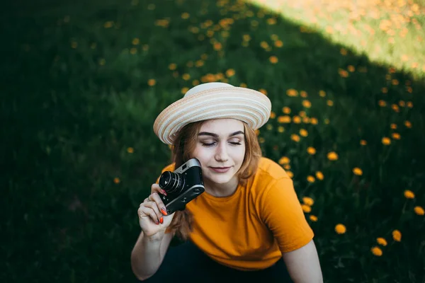 Turuncu Tişörtlü Genç Bir Kız Elinde Retro Kamerayla Çimlere Uzanmış — Stok fotoğraf