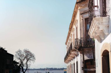Orta büyüklükte bir koloni evi. Beyaz kirli duvarları ve Rio de La Plata 'nın yan manzaralı pencereleriyle dolu..