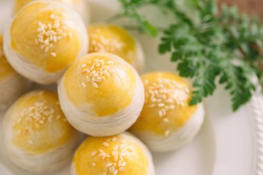 Çin usulü gevrek pasta ya da ay çöreği tatlı mung fasulyesi ezmesi ve tuzlu yumurta sarısını beyaz susam ile süslenmiş ve ayrıntıları sunmak için yakın plan makro konseptle süslenmiş. Ev yapımı fırın konsepti.