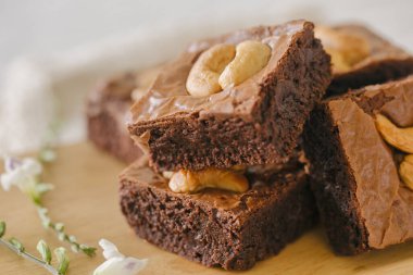 Tahta tabakta kaju fıstıklı taze pişmiş çikolatalı kek. Lezzetli, acı tatlı, çiğnenmiş ve şekerli. Brownie çikolatalı kekin bir çeşidi. Ev yapımı fırın konsepti.