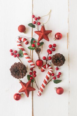 Kozalaklı beyaz odun ya da kozalaklı kozalaklı kozalak, kırmızı kutsal toplar, parıldayan yıldız, baston şeker ve Noel konseptinde mücevher. Üst görünümde dikey tahta arkaplan noel duvar kağıdı için düz kopya alanı