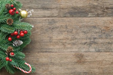 Eski ahşap desen, Noel temalı çam yaprağı, kozalak, kutsal toplar, altın top ve şeker kamışlarıyla dekore edilir. Üst görünümde ahşap arkaplan noel duvar kağıdı için kopya alanı ile yatıyordu