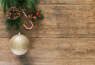 Eski ahşap döşeme, çam yaprağı, kozalak, kutsal toplar ve Noel konseptinde ışıltılı altın top ile dekore edilir. Üst görünümde ahşap arkaplan noel duvar kağıdı için kopya alanı ile yatıyordu.