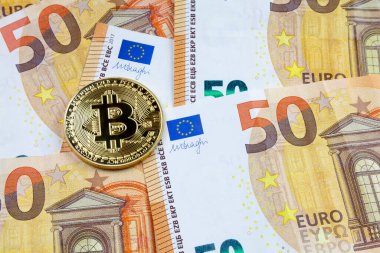 50 Euro 'luk banknotların üstünde altın bir Bitcoin' e yakın plan..
