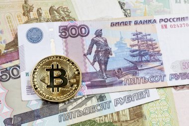 Rus Rublesi banknotlarının üstünde altın bir Bitcoin 'e yakın plan..