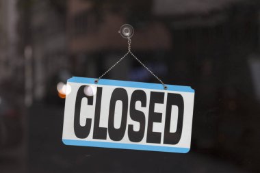 Bir mağazanın penceresindeki kapalı bir tabelaya yakın çekim.