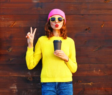Kahve fincanı wo üzerinde renkli giysileri ile güzel kadın moda