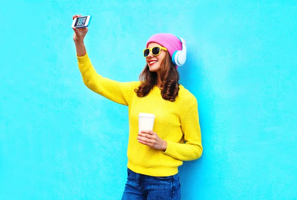 Moda chica sonriente fresco en los auriculares escuchar música tomando p — Foto de Stock