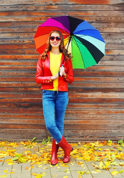 Pretty young smiling woman with colorful umbrella wearing a red — Stock Photo, Image