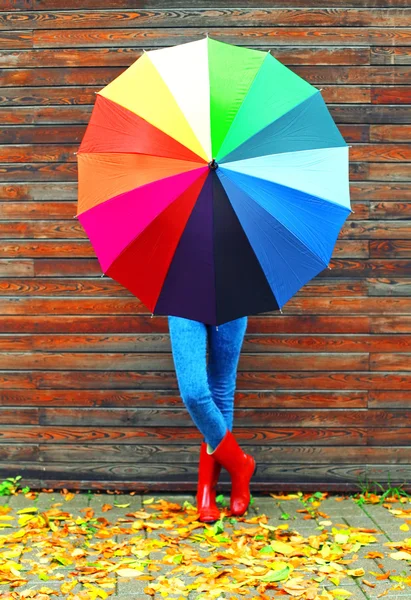 Kadın kırmızı bir kauçuk giymiş renkli şemsiye ile Tortum içinde çizme — Stok fotoğraf