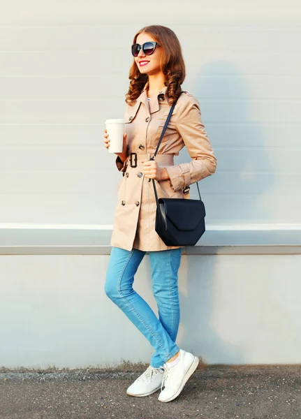 Fashion pretty young woman with coffee cup wearing a coat and ha — Stockfoto