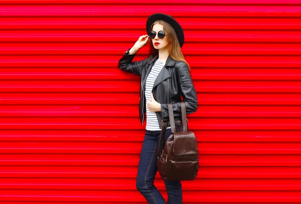 Fashion young woman in black rock style stands over empty red ba — Stock fotografie