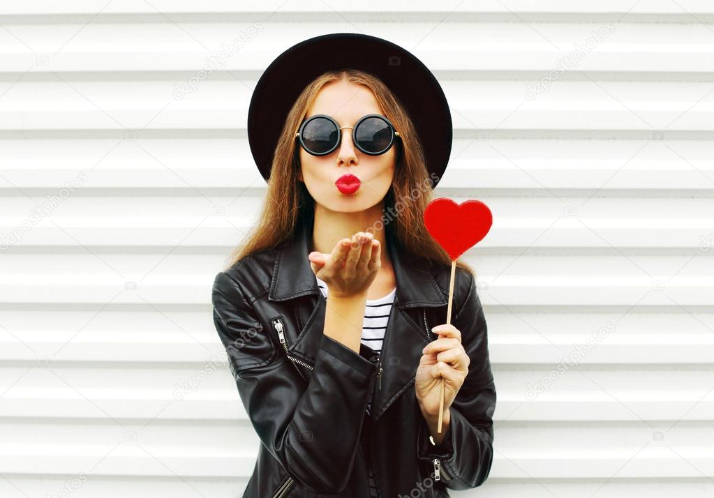 Fashion pretty sweet young woman with red lips sends air kiss wi