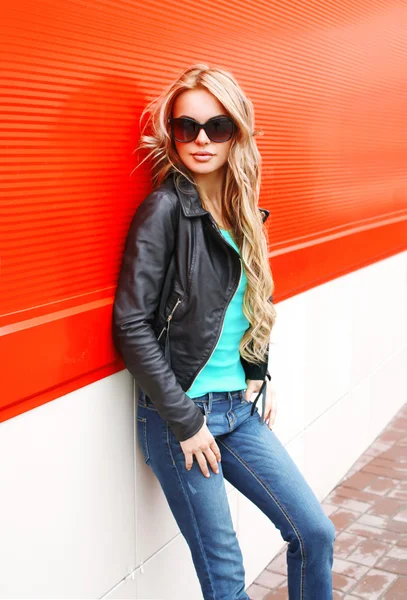 Fashion blonde woman in black rock jacket sunglasses at city ove