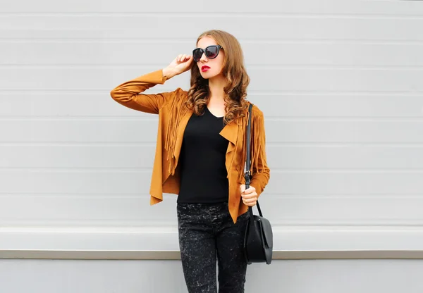 Moda mujer joven con una chaqueta gafas de sol bolso negro ov —  Fotos de Stock