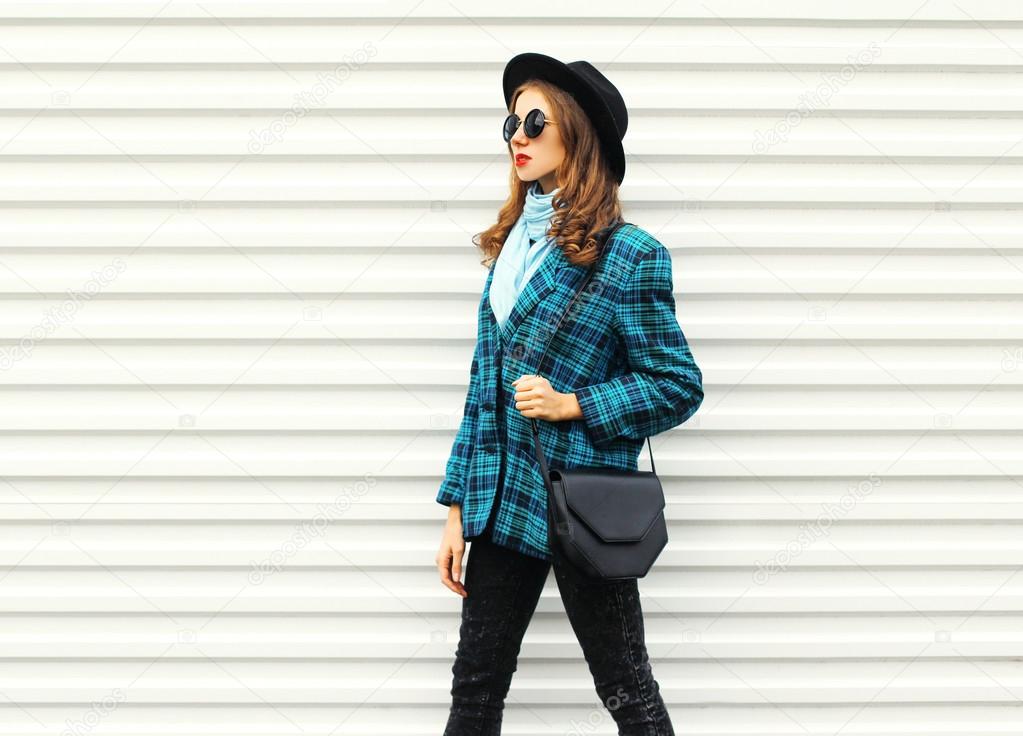 Fashion young woman wearing black hat checkered coat jacket hand