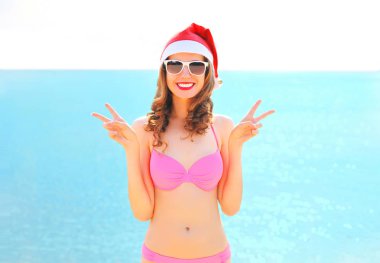 Noel beac kırmızı santa şapka içinde oldukça gülümseyen kadın portre