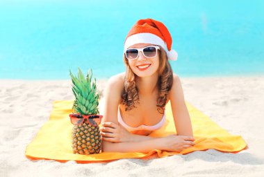 Noel genç gülümseyen kadın portre kırmızı santa şapka ve çam