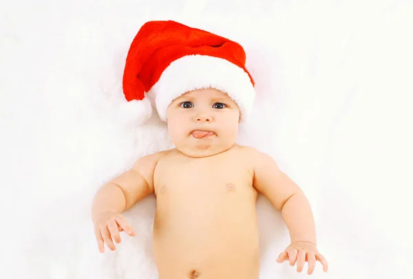 Christmas and family concept - cute funny baby in red santa hat — Stock Photo, Image