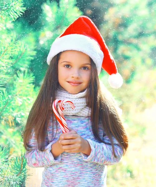 Criança de Natal menina em santa chapéu vermelho com pirulito doce — Fotografia de Stock