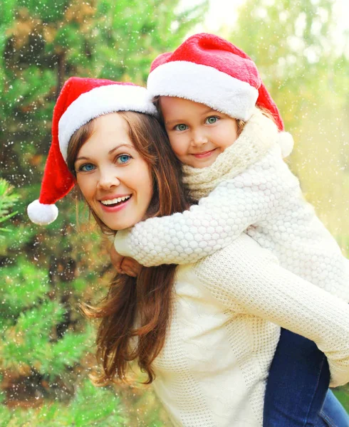 Christmas family child hugging mother in santa red hats together — Stock Photo, Image